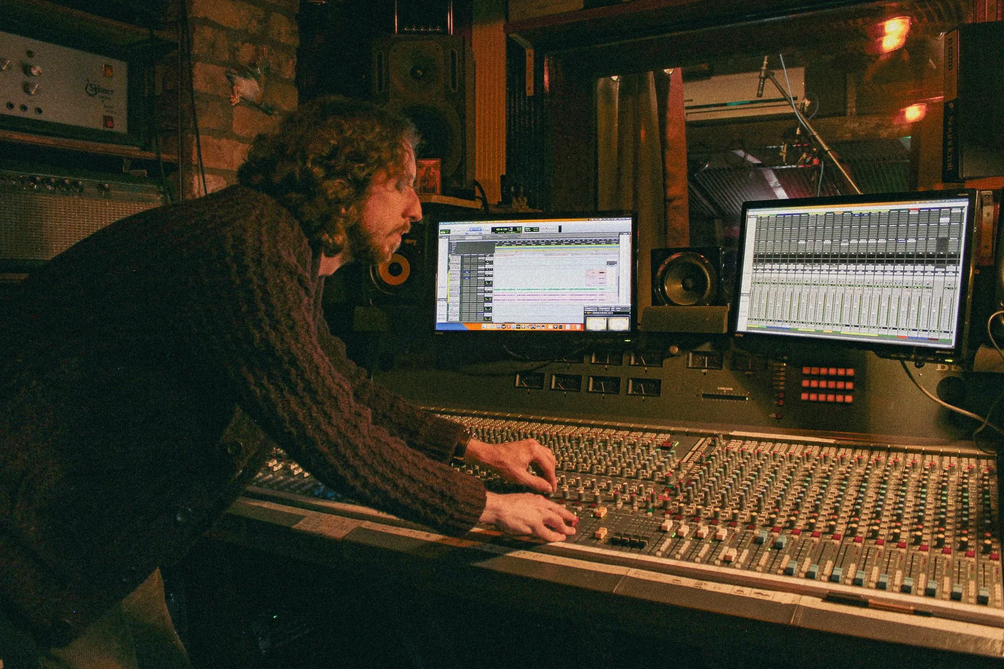 Man leaning over mixing desk