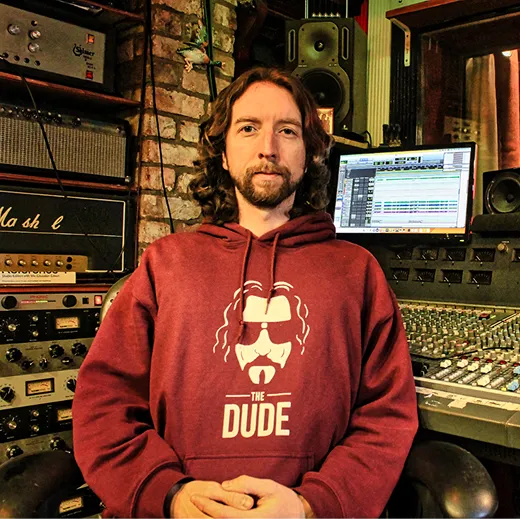 Man leaning over mixing desk